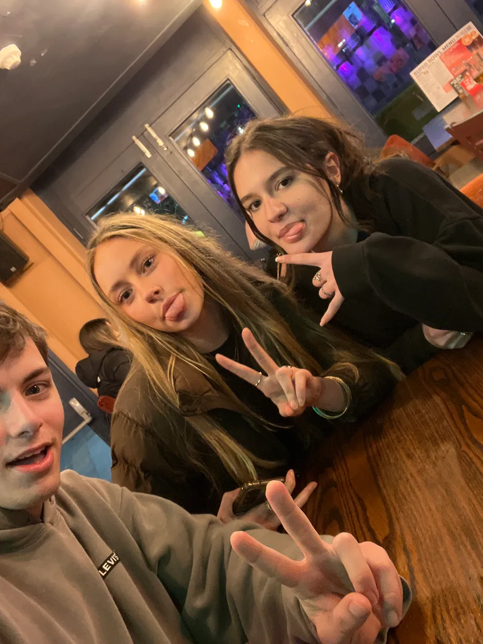 Three teammates sitting together around a pub table