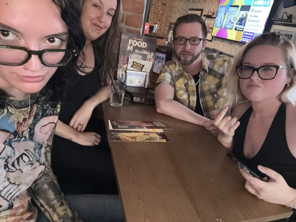Four teammates sitting around a wooden pub table
