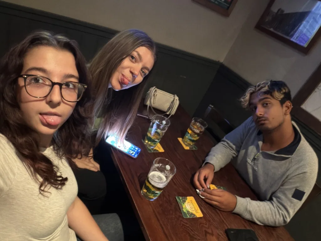 Three quiz teammates seated together around a pub table